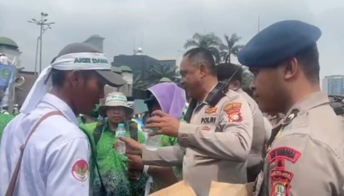**Pelayanan Humanis di DPR: Polda Metro Berikan Air Mineral ke Massa Guru dalam Cuaca Panas**